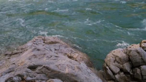 青い色合いの美しい嵐の山の川が急速に大きな石や岩の間を閉じる流れます。山の川は魅力的で注目を集めています。水平4kビデオスローモーション. - 映像、動画