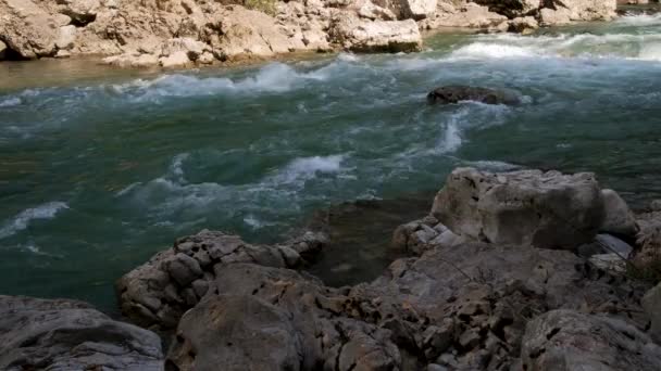 青い色合いの美しい嵐の山の川が急速に大きな石や岩の間を閉じる流れます。山の川が魅力的で注目を集める. - 映像、動画