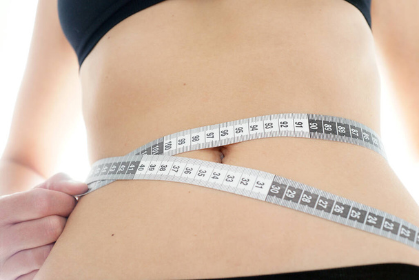 Giovane donna magra misura la sua circonferenza dell'anca dopo l'allenamento di fitness - Foto, immagini