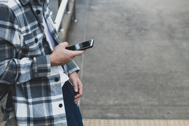 Teenager nutzt Smartphone-Gerät für Online-Netzwerktechnologie Internet; Mann benutzt Handy im öffentlichen Park - Foto, Bild