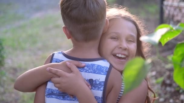Hermano y hermana abrazan juntos al aire libre - Metraje, vídeo