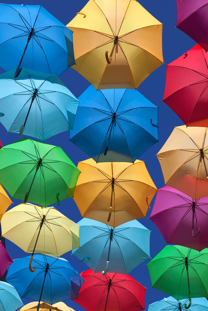 Φόντο πολύχρωμες ομπρέλες σε ένα δρόμο - Φωτογραφία, εικόνα