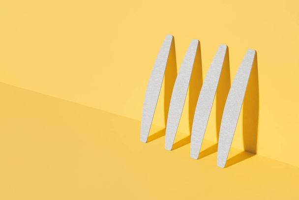 Set of nail files, emery board for nails of different shapes and different stiffness on a yellow background. isometric diagonal projection.Minimal, Trendy shadows, Modern photo.Mock up for manicurist - Foto, imagen