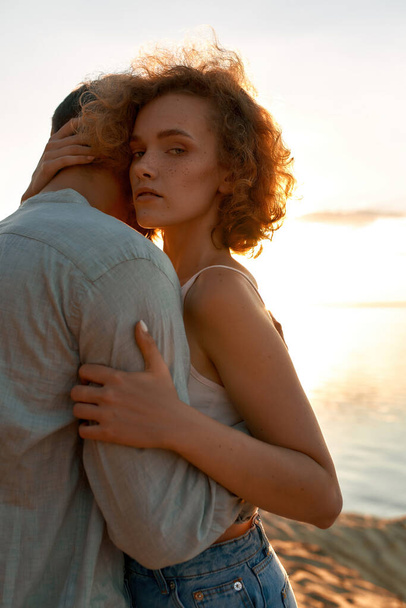 Portrait of tender young lovers hugging at sunset - Фото, зображення