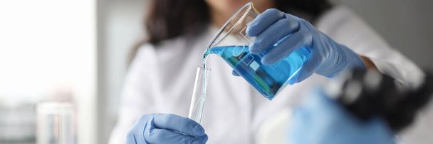 Técnico de laboratorio con guantes vierte sustancia química en el tubo de ensayo - Foto, Imagen