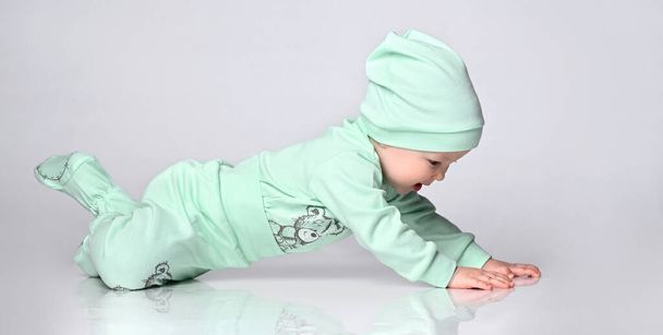 Little baby toddler wearing body set of slider and hat crawling - 写真・画像