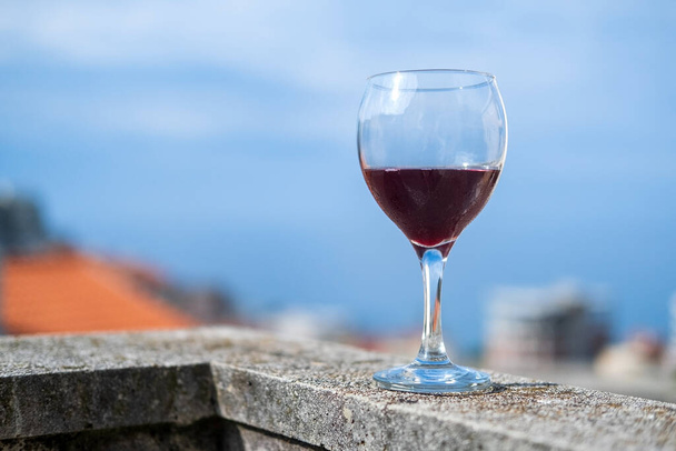 un verre de vin rouge froid sur le balcon contre - Photo, image