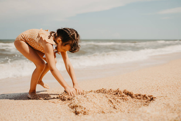 Εξάχρονο κορίτσι με κίτρινο μαγιό στην παραλία - Φωτογραφία, εικόνα