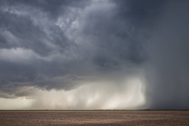 Een zware storm met een intense neerslag schacht dumpt regen en hagel over het vlakke landschap van Kansas. - Foto, afbeelding