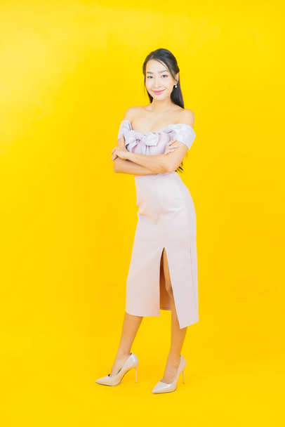 Ritratto bella giovane donna asiatica sorriso con azione su sfondo di colore - Foto, immagini