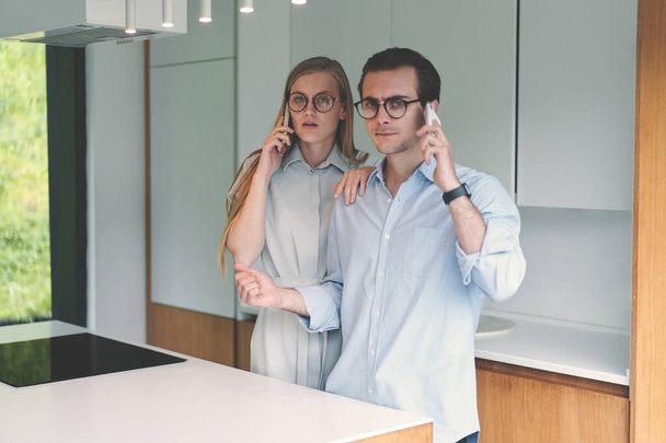 Evde çalışan ve telefonla konuşan genç bir çift. - Fotoğraf, Görsel