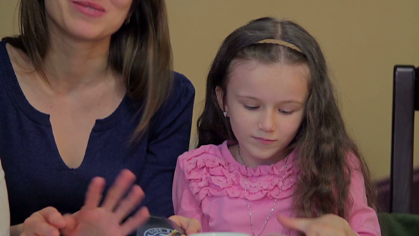 twee vrouwen met een klein meisje in café - Video