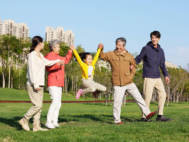 A happy family of five walking in the park - Fotó, kép