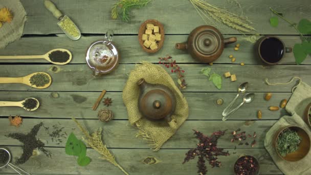 Tea on an old wooden table. Flat lay. Still life with different types of tea: black, green, mate, hibiscus, floral, fruit, herbal.The hands of two men and one woman put cups of tea on the table (green, hibiscus and black tea). - Footage, Video