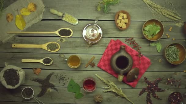 Tea egy régi fából készült asztalon. Lapos fekvés. Csendélet különböző típusú tea: fekete, zöld, haver, hibiszkusz, virágos, gyümölcs, gyógynövény. - Felvétel, videó