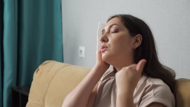 Brünette Frau leidet unter der Hitze und wischt sich mit einer Papierserviette ab - Filmmaterial, Video