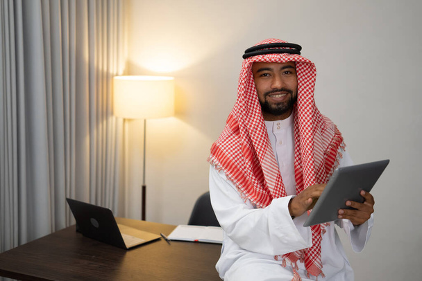 an Arab businessman using a laptop works standing at a desk - Foto, afbeelding