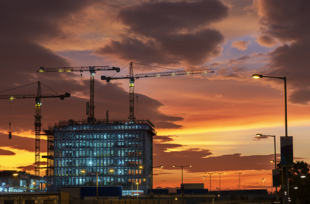 Grúa en el sitio de construcción para edificios de gran altura bajo la puesta del sol - Foto, Imagen