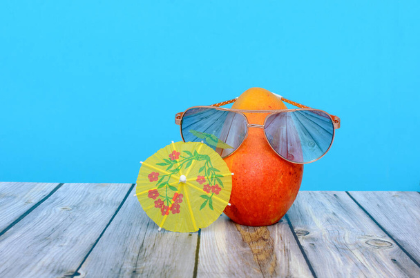 Mango s brýlemi na stole a deštníkem. Letní pozadí. - Fotografie, Obrázek