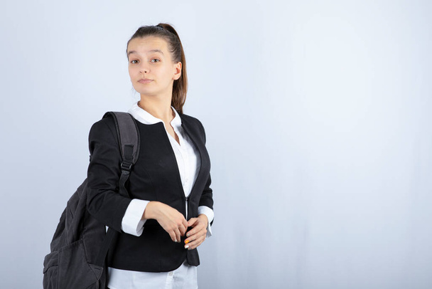 Portrait of young woman with schoolbag standing on white background. High quality photo - Foto, imagen