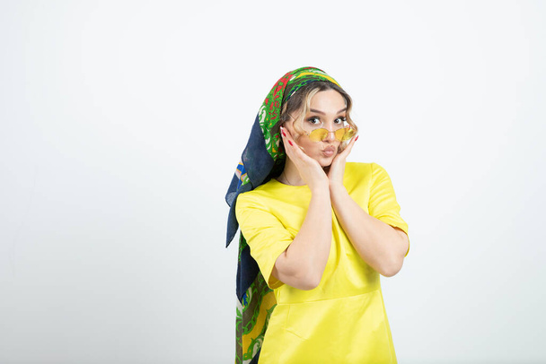 Foto van een leuke vrouw in hoofddoek staand en poserend in een bril. Hoge kwaliteit foto - Foto, afbeelding