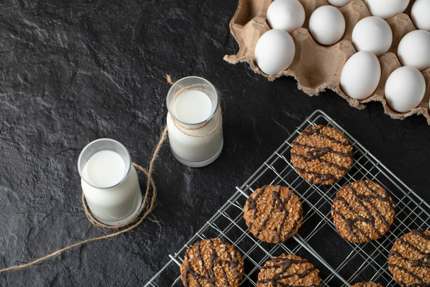 Fresh cookies with egg and milk on black background. Homemade cookies. High quality photo - Фото, зображення