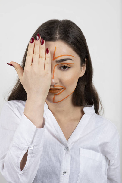 Image of young woman with painted face covering eye with hand . High quality photo - Photo, Image