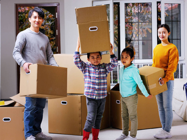 A happy family of four move home - 写真・画像
