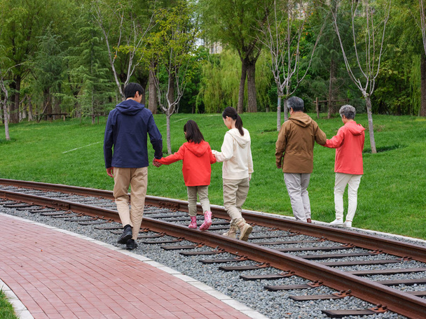 A happy family of five walking outdoors - Фото, изображение