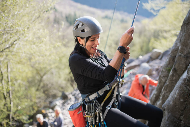 Senior woman climbing rocks outdoors in nature, active lifestyle. - Foto, Imagem