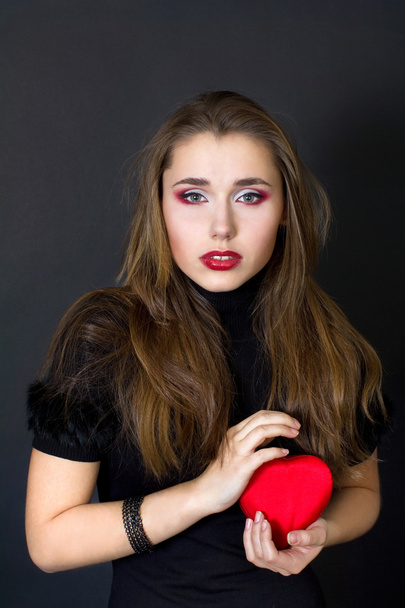 Young woman holding a red heart - Foto, afbeelding