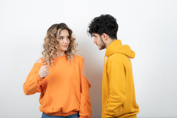 Young curly haired punching at her brunette lover over white. High quality photo - Photo, Image