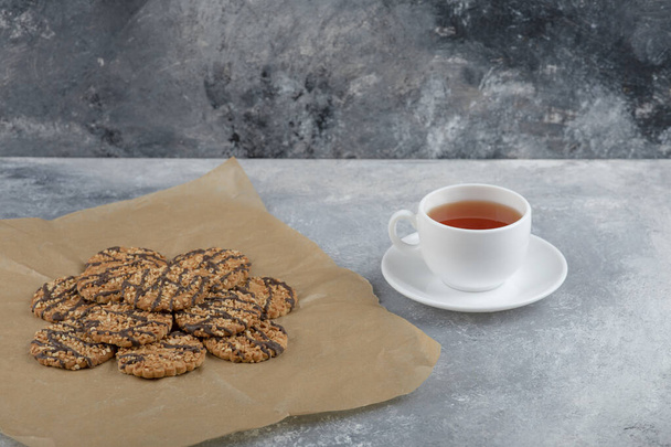 Μερικά υγιεινά μπισκότα βρώμης με σιρόπι σοκολάτας με ένα φλιτζάνι τσάι. Υψηλής ποιότητας φωτογραφία - Φωτογραφία, εικόνα