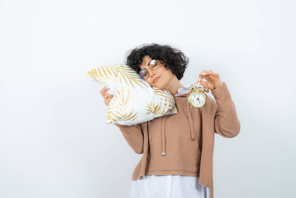 mujer joven posando con almohada sobre un fondo blanco - Foto, imagen
