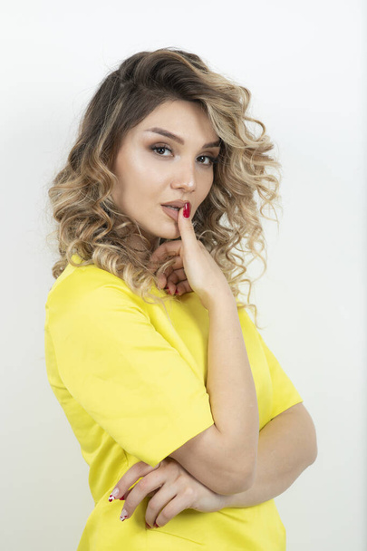 Blonde curly hair woman in yellow dress looking seductively. High quality photo - Zdjęcie, obraz