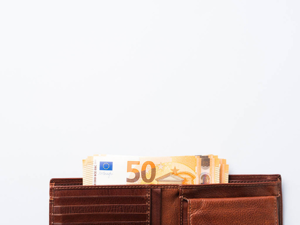 Νόμισμα σε ευρώ 50 τραπεζογραμμάτια αξίας σε ακριβό δερμάτινο πορτοφόλι σε μπλε φόντο - Φωτογραφία, εικόνα