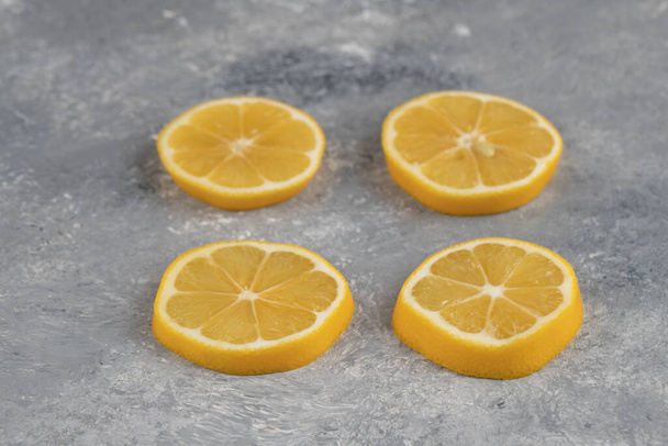 大理石の背景にサワーレモンの4枚のスライス。高品質の写真 - 写真・画像