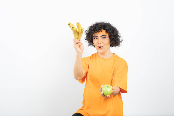 mujer joven con fruta posando sobre fondo blanco - Foto, imagen