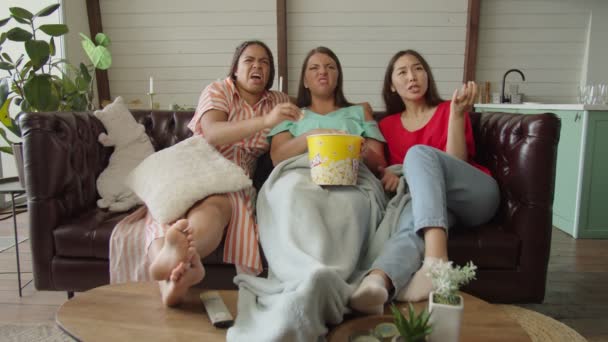 Femmes de race mixte exprimant leur insatisfaction en regardant la télévision à l'intérieur - Séquence, vidéo