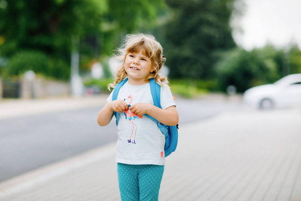 Cute little preschool girl going to playschool. Healthy toddler child walking to nursery and kindergarten. Happy child with backpack on city street, outdoors. City, traffic, safety on school way. - Fotoğraf, Görsel