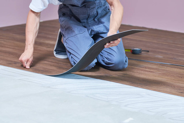 worker joining vinyl floor covering at home renovation - Foto, afbeelding