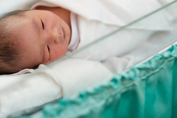 new born infant asleep in the blanket in delivery room - 写真・画像