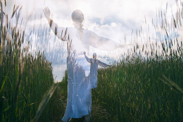 Mooie vrouw wandelen in het veld overdag, romantische stemming, dubbele belichting - Foto, afbeelding