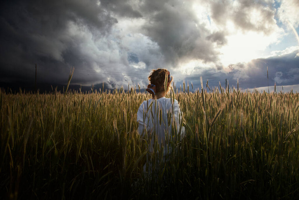 Beautiful woman walking in field at daytime, romantic mood - Photo, Image