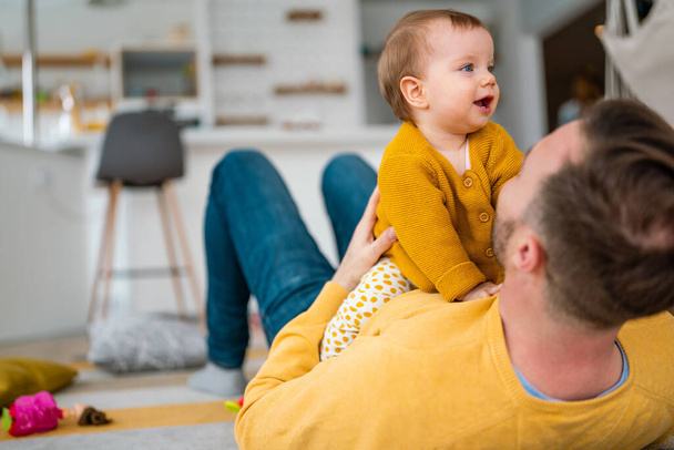 Happy young father playing with little daughter at home. Family happiness love home concept - 写真・画像