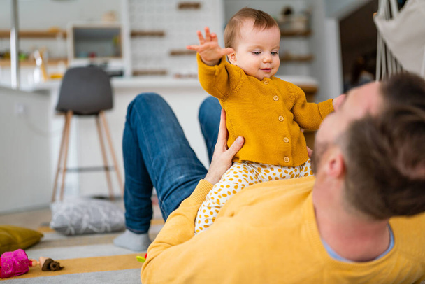 Happy young father playing with little daughter at home. Family happiness love home concept - Photo, Image