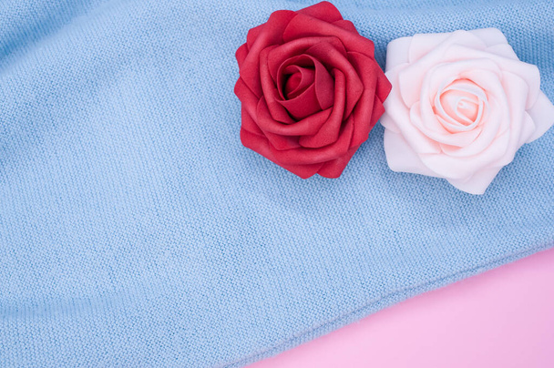 A closeup of the decorative artificial colorful roses on the blue fabric - Foto, Bild
