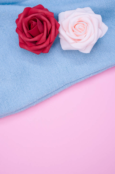 A closeup of the decorative artificial colorful roses on the blue fabric - 写真・画像