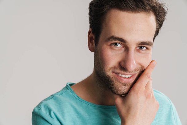 Happy attractive young casual man isolated over gray background, close up, posing - 写真・画像