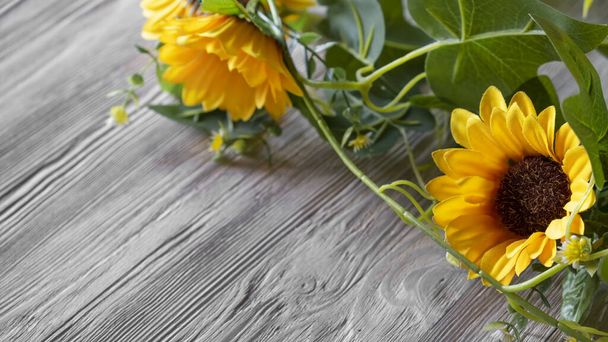 Artificial sunflowers on a wooden background. Copy space - Фото, зображення
